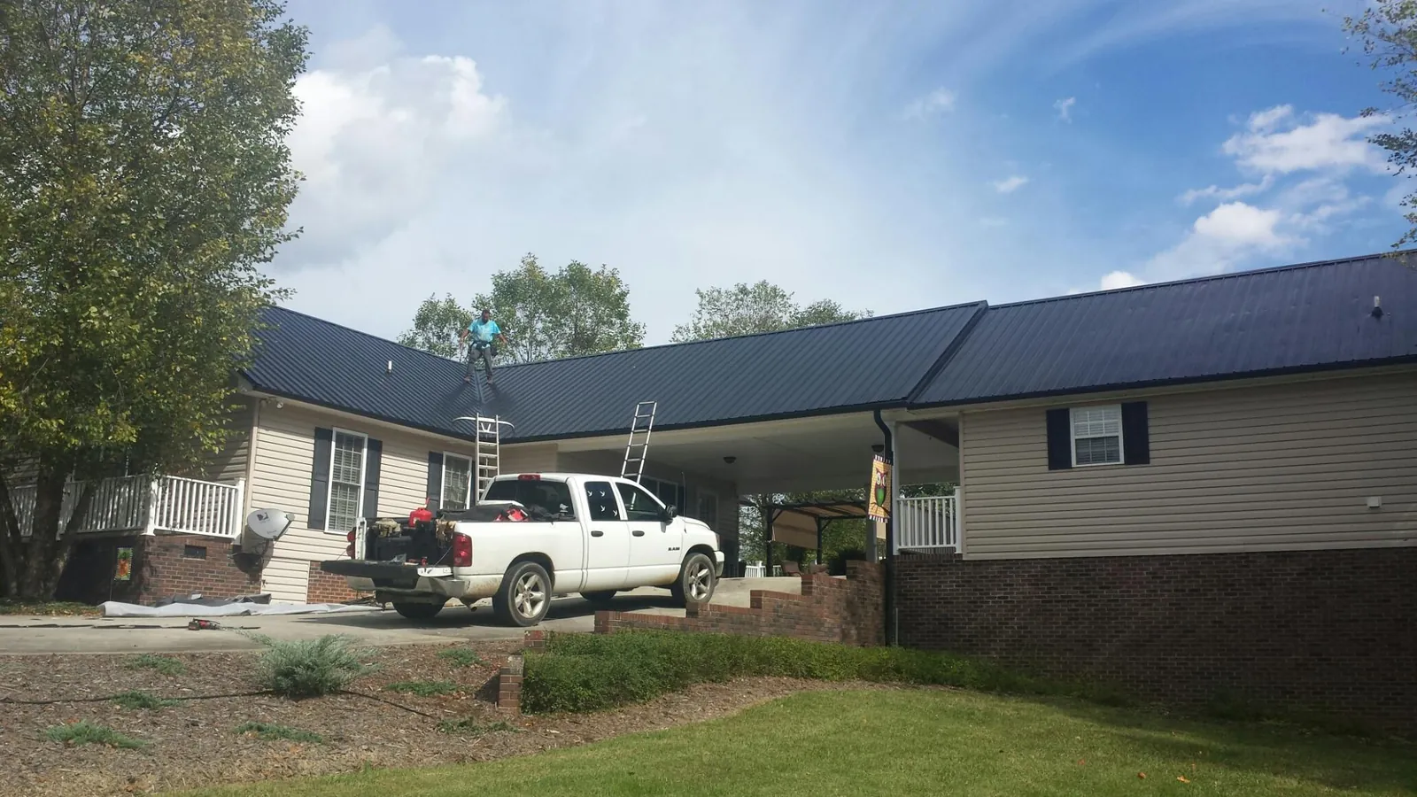 Black metal roof over a home and attached breezeway with ladders set in Rockland